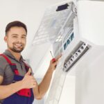 An Air Conditioning Technician Gives a Thumbs Up While Working.